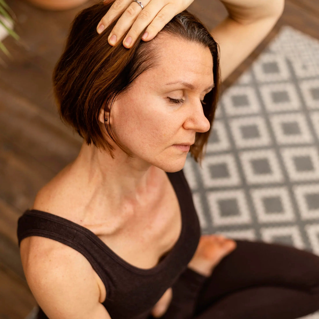 Woman in a yoga pose touching her hair